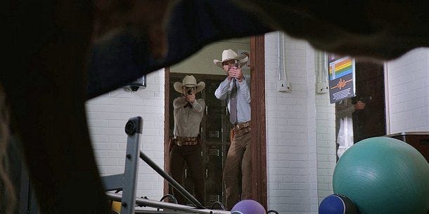 Walker Cordell Micki holding guns on cow in Wolverine drape. Walker Cordell Micki holding guns on cow in Wolverine drape.