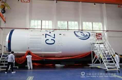 The Long March 3B/E's payload adapter and second-stage being prepared for flight, as well as a first-stage booster being lifted during assembly for launch.