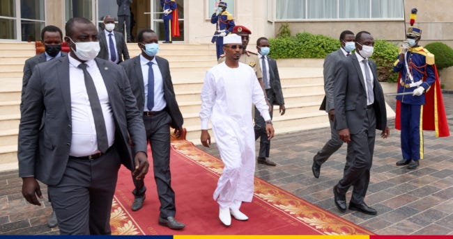 Mahamat Déby, en boubou blanc et entouré de gardes du corps, descendant les marches du palais présidentiel tchadien