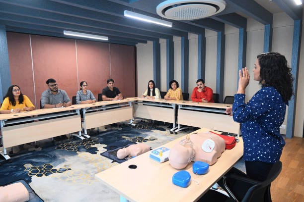 A woman Instructor explaining the class while conducting CPR training stock photo