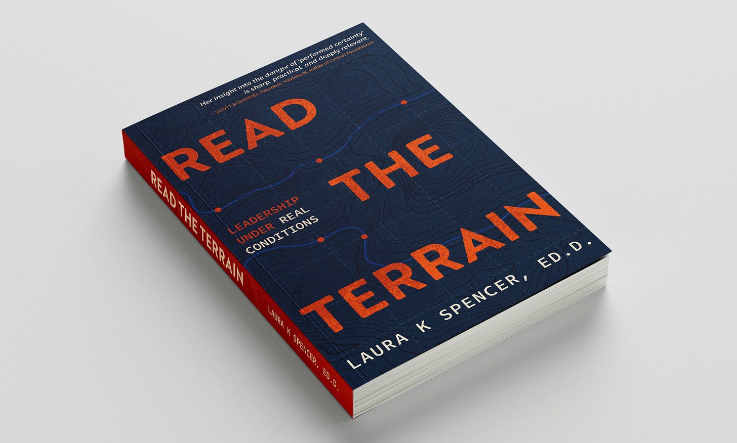 Paperback copy of Read the Terrain: Leadership Under Real Conditions by Laura K Spencer, Ed.D. The navy cover features orange title lettering over a topographic map with a winding blue trail line. An endorsement at the top reads: "Her insight into the danger of 'performed certainty' is sharp, practical, and deeply relevant." Scott Schimmel, President, YouSchool, author of Critical Foundations. Paperback copy of Read the Terrain: Leadership Under Real Conditions by Laura K Spencer, Ed.D. The navy cover features orange title lettering over a topographic map with a winding blue trail line. An endorsement at the top reads: "Her insight into the danger of 'performed certainty' is sharp, practical, and deeply relevant." Scott Schimmel, President, YouSchool, author of Critical Foundations.