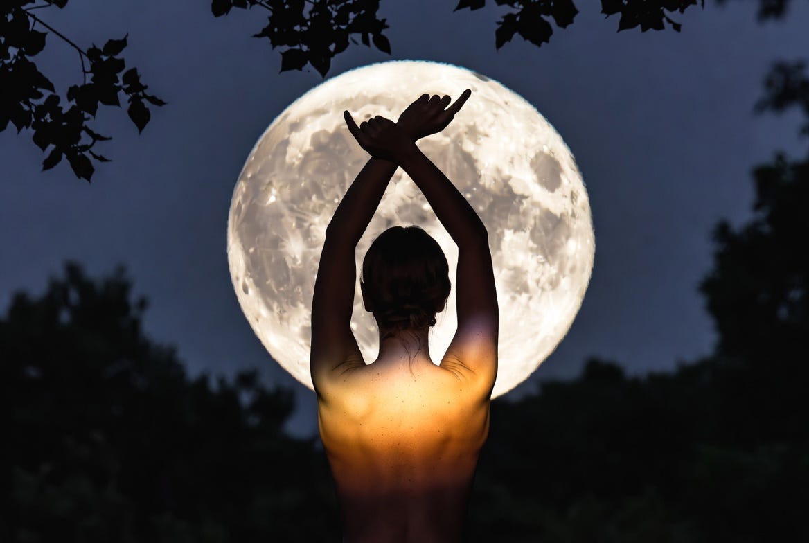 A woman moon bathing in a serene nighttime setting, illuminated by a full moon in a natural environment.