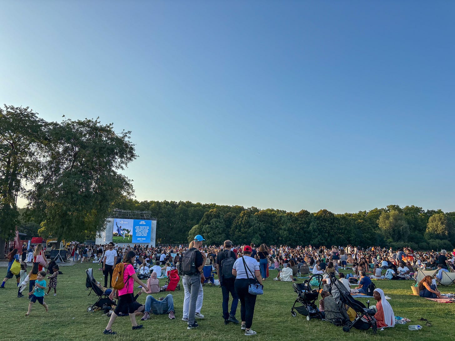 Crowd gathered on the grass for an outdoor film screening at Parc de la Villette, Paris Crowd gathered on the grass for an outdoor film screening at Parc de la Villette, Paris