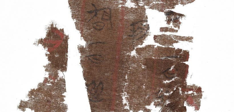 Torn pieces of brown cloth with faded black calligraphy. Torn pieces of brown cloth with faded black calligraphy.