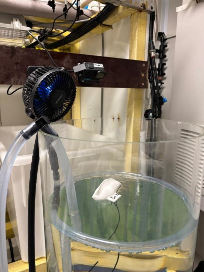 A large glass container with a fan in it

AI-generated content may be incorrect.