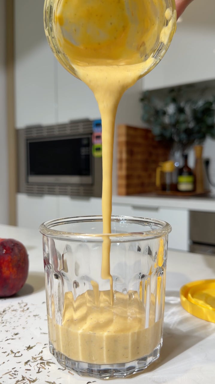 Peach brown butter salad dressing being poured into a glass jar