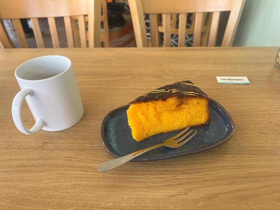 A piece of cake on a plate next to a mug

AI-generated content may be incorrect.