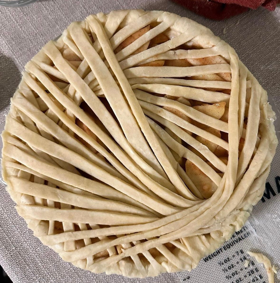 An unbaked pie with an intricate design on top.