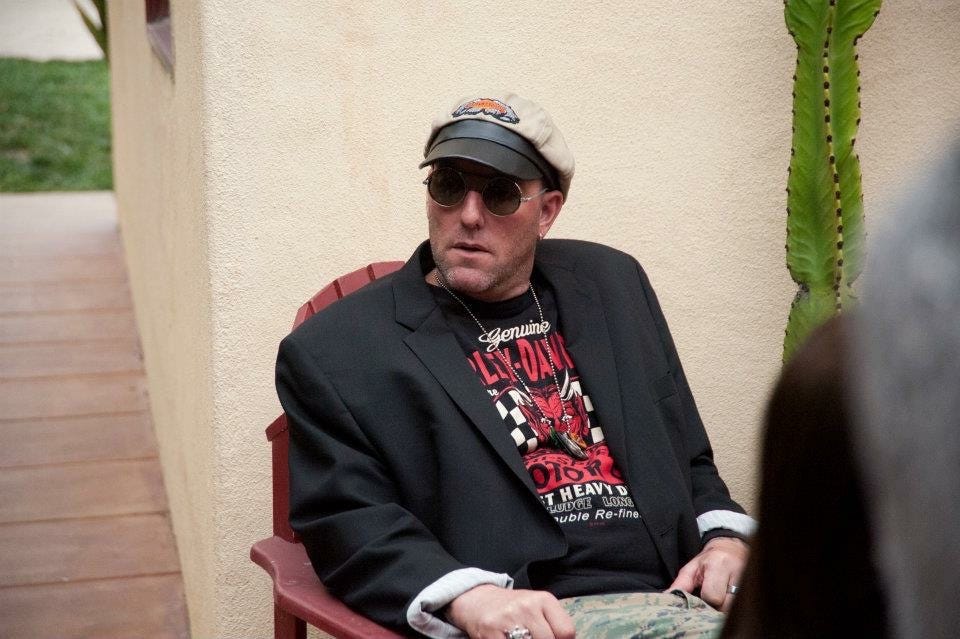 white man in sunglasses and hat wearing harley davidson t shirt sitting in chair white man in sunglasses and hat wearing harley davidson t shirt sitting in chair