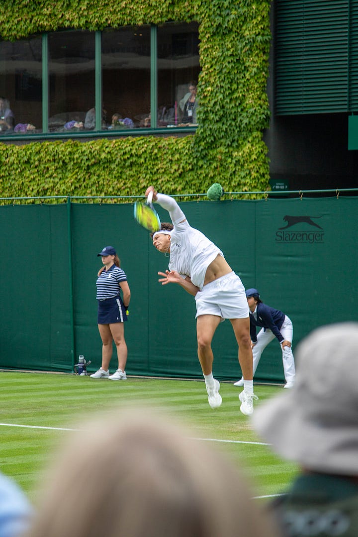Four scenes from Wimbledon: Ben Shelton serving on an outside court, ball boys and ball girls huddled in Wimbledon uniforms, rain covers pulled across a court showing the Wimbledon crest, and the Royal Box on Centre Court during the Federer ceremony