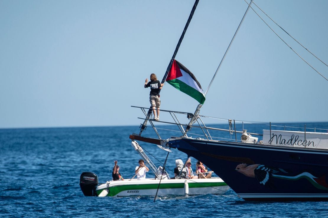 Climate activist Greta Thunberg stands near a Palestinian flag after boarding the Madleen boat on June 1, 2025.