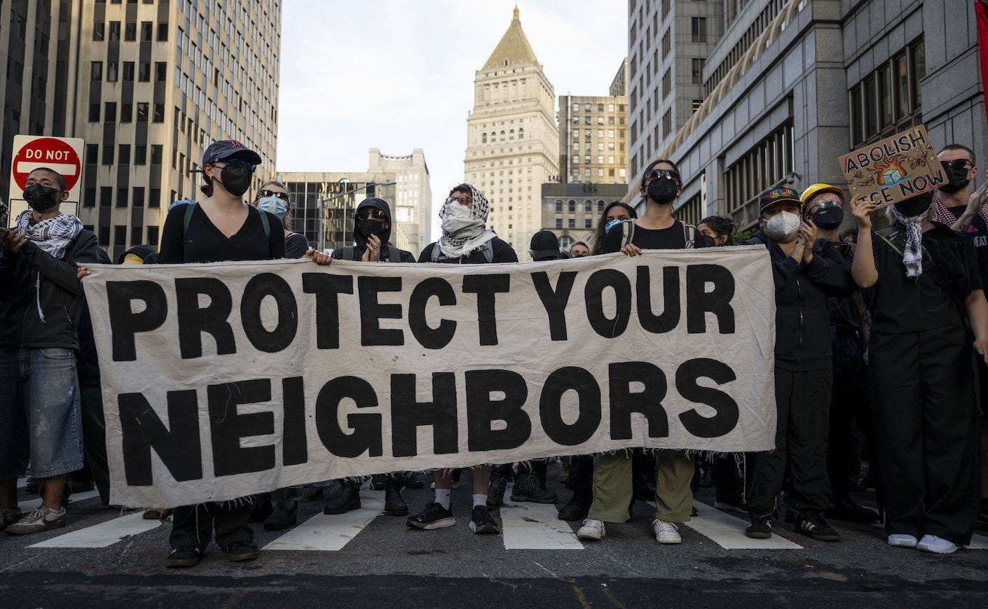 protestors holding a sign that says "protect your neighbors" in NYC protestors holding a sign that says "protect your neighbors" in NYC