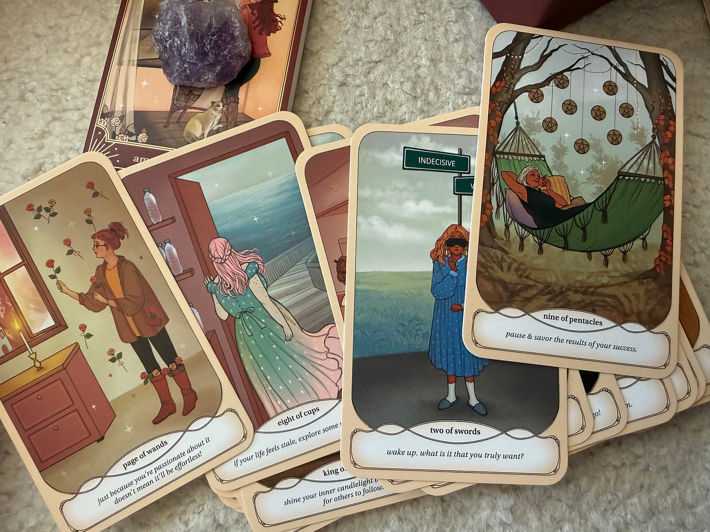 Close up illustration of Cozy witch tarot cards including Page of Wands, Eight of Cups, and Two of Swords Close up illustration of Cozy witch tarot cards including Page of Wands, Eight of Cups, and Two of Swords