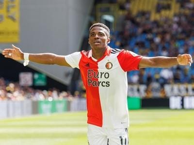 A person in a football uniform with his arms out

Description automatically generated