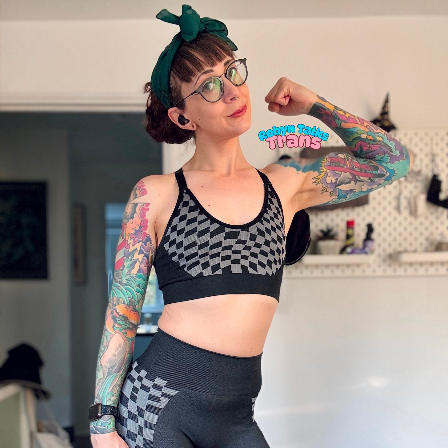 A photo of Robyn in gym gear, flexing her left arm and looking at the camera A photo of Robyn in gym gear, flexing her left arm and looking at the camera