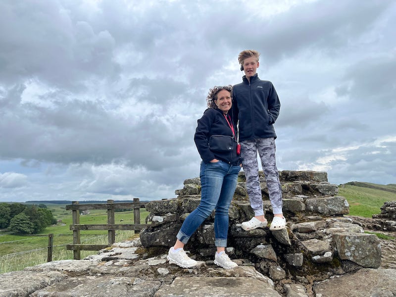 2025-6-22 Becky and Hudson standing on Hadrian’s Wall, photo by author