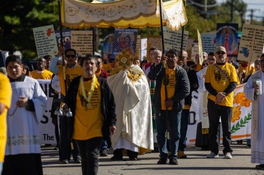 The Rev. Larry Dowling marches with the Eucharist in a procession led by the Coalition for Spiritual and Public Leadership from St. Eulalia Catholic Church in Maywood to the Immigration and Customs Enforcement processing facility in Broadview, Oct. 11, 2025. Eucharistic ministers, including Dowling, later attempted to commemorate Communion with detainees in the ICE processing facility. (Dominic Di Palermo/Chicago Tribune)