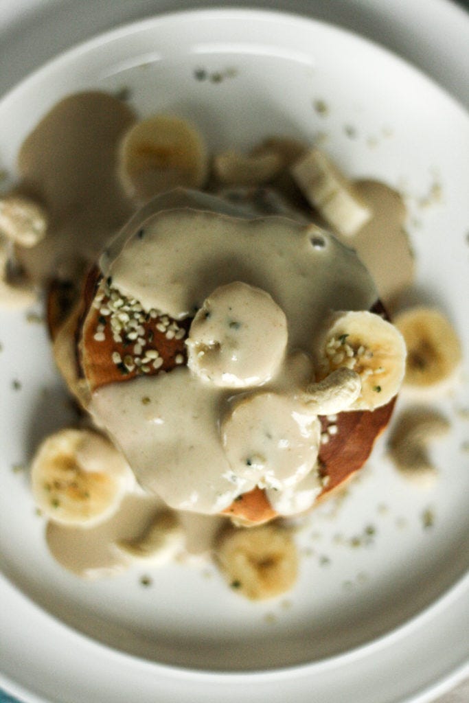 Bananas and creamy cashew drizzle tops these gluten free coconut pancakes. 