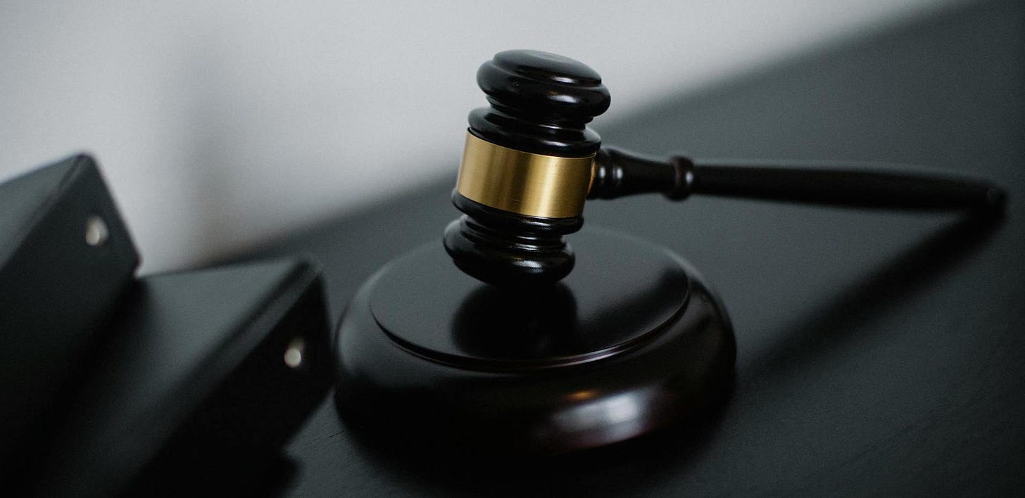 A gavel sitting upright on a black desk