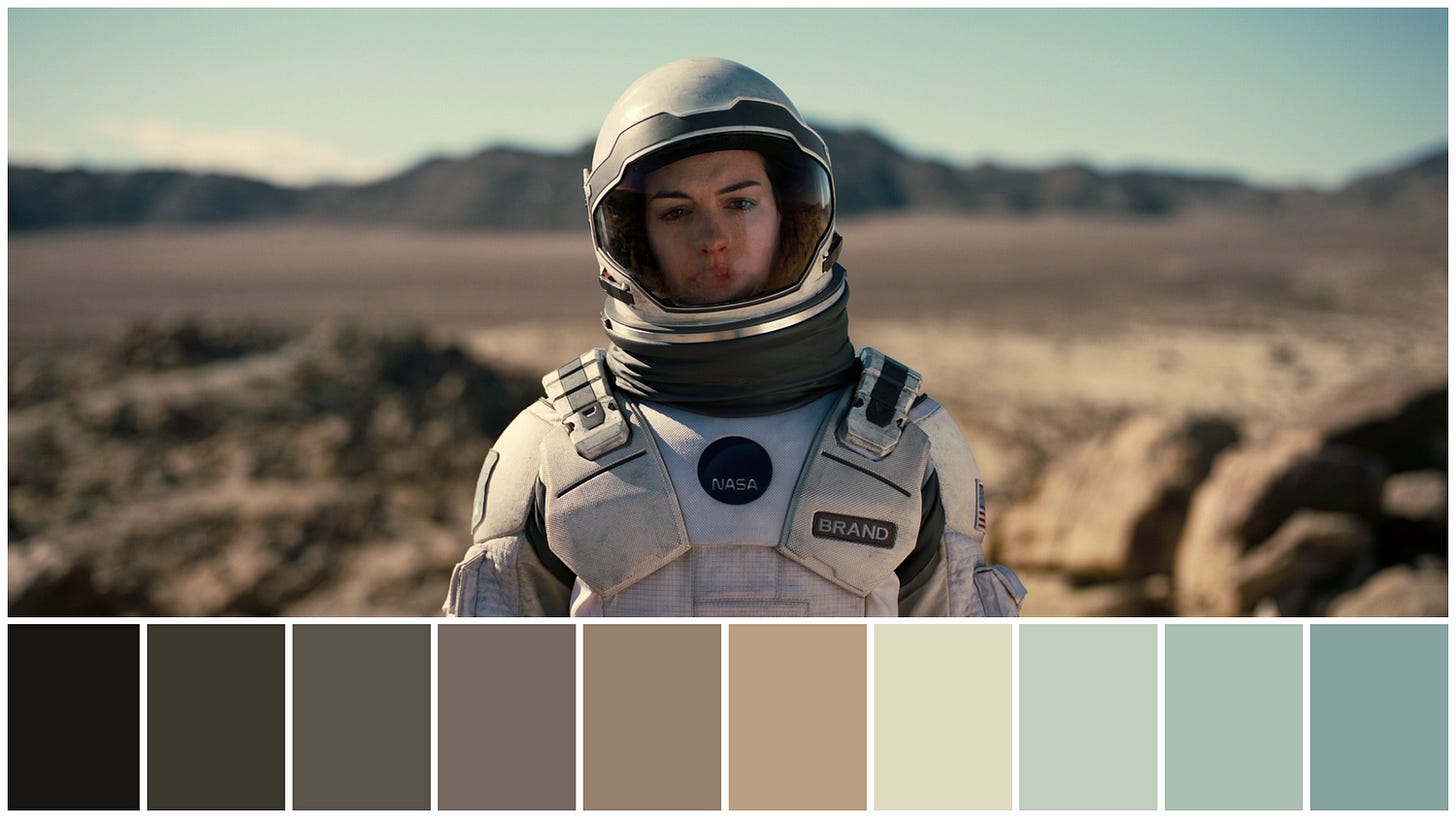Astronauta em traje espacial da NASA em um deserto árido, com montanhas ao fundo. Abaixo, paleta de cores com tons neutros.