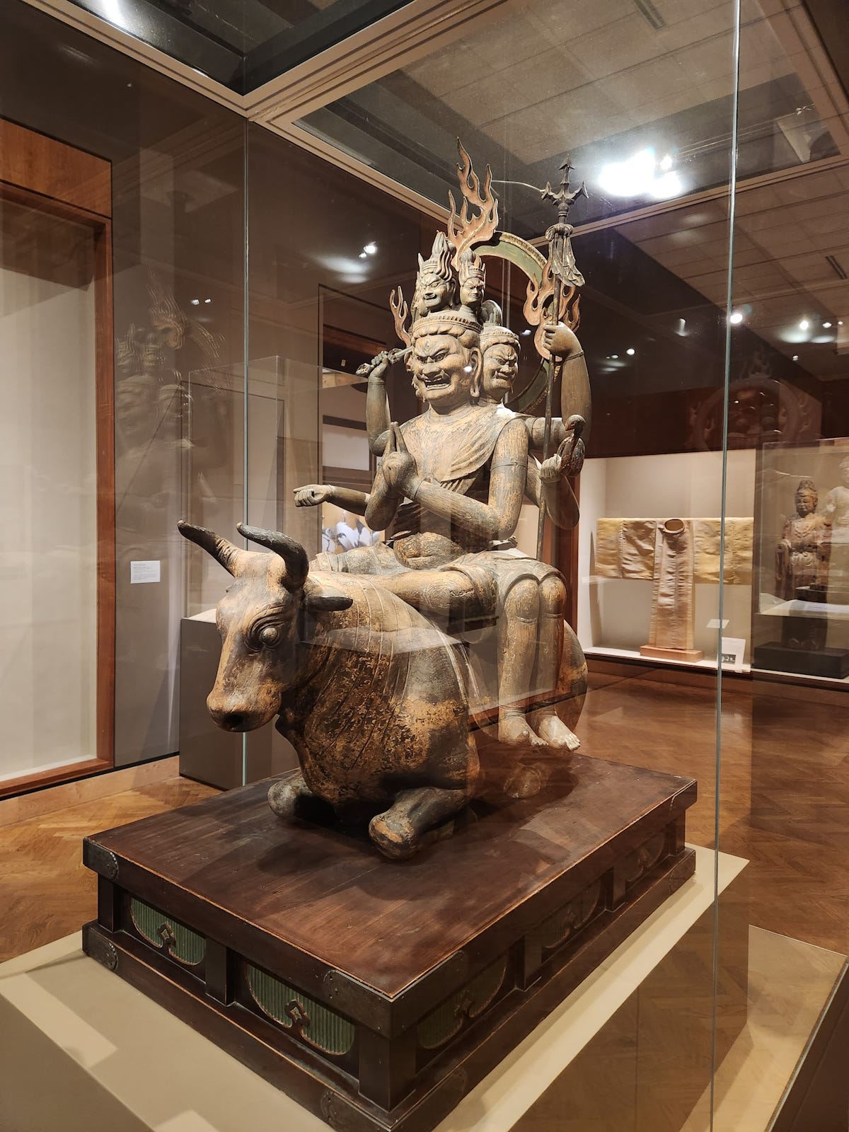 A wrathful royal divinity, carved in wood, atop a kneeling water buffalo. He has six faces, legs and arms and is riding a kneeling, pony-size water buffalo. The king’s foremost and largest face bears an expression of gleeful fury, and he holds a sword in one hand, a trident in another and, in a third, a noose for capturing people and dragging them on to the right spiritual path. A wrathful royal divinity, carved in wood, atop a kneeling water buffalo. He has six faces, legs and arms and is riding a kneeling, pony-size water buffalo. The king’s foremost and largest face bears an expression of gleeful fury, and he holds a sword in one hand, a trident in another and, in a third, a noose for capturing people and dragging them on to the right spiritual path.