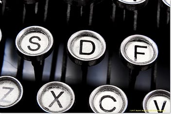 Close-up view of vintage typewriter keys, highlighting the letters S, D, F, Z, X, C, and V with a nostalgic touch on the metal rims.
