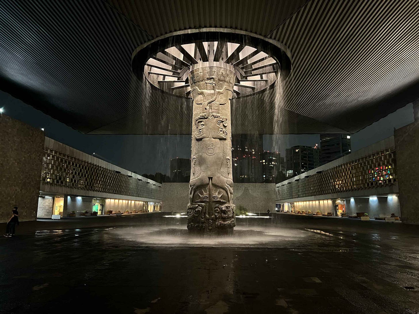An elaborate column holding up a large roof over a courtyard, with water streaming from a circular hole around the column. An elaborate column holding up a large roof over a courtyard, with water streaming from a circular hole around the column.