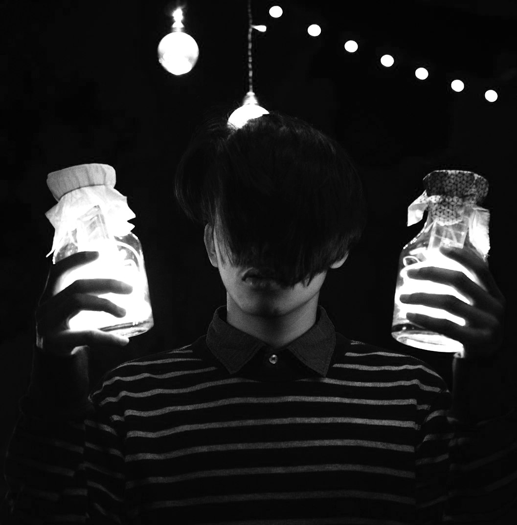 a man holding two jars of liquid in his hands a man holding two jars of liquid in his hands