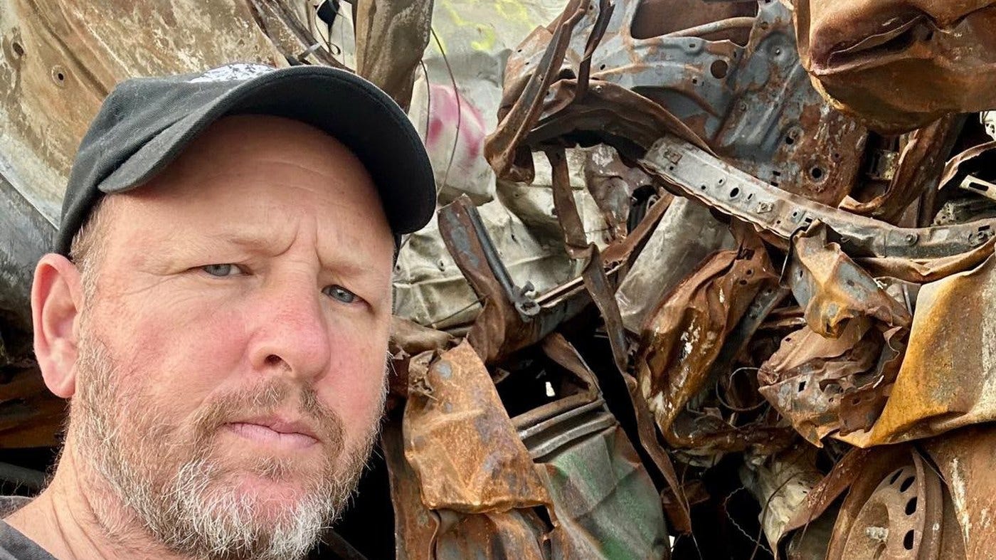 David Sussman beside the stacked wreckage of vehicles burned on October 7, at the Tkuma site in southern Israel David Sussman beside the stacked wreckage of vehicles burned on October 7, at the Tkuma site in southern Israel
