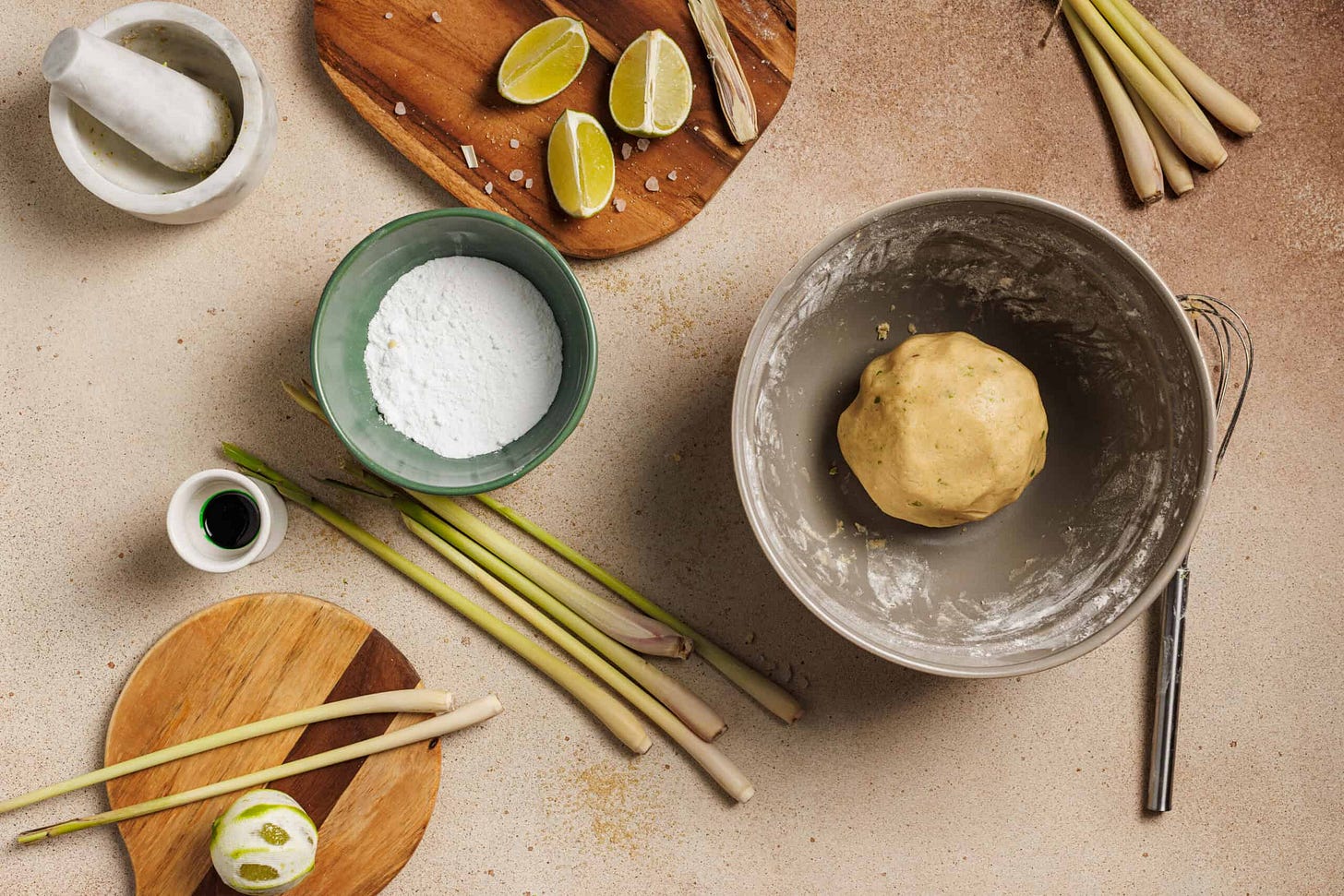 A table of ingredients with a freshly made dough ball for lemongrass cookies.
