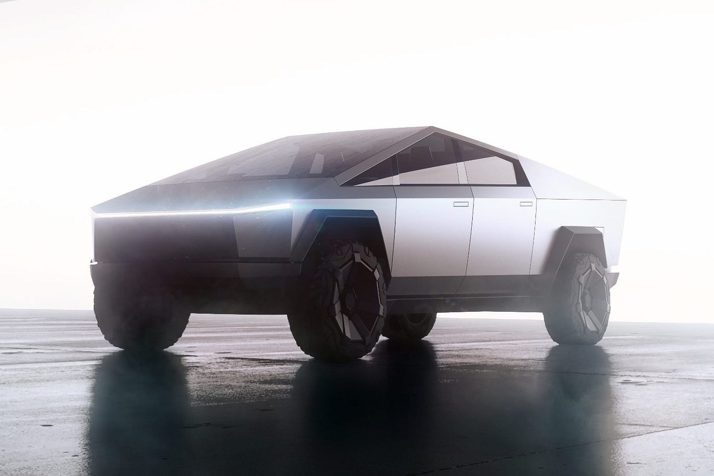 2024 Tesla Cybertruck parked on wet pavement with headlights on and bright light behind it.