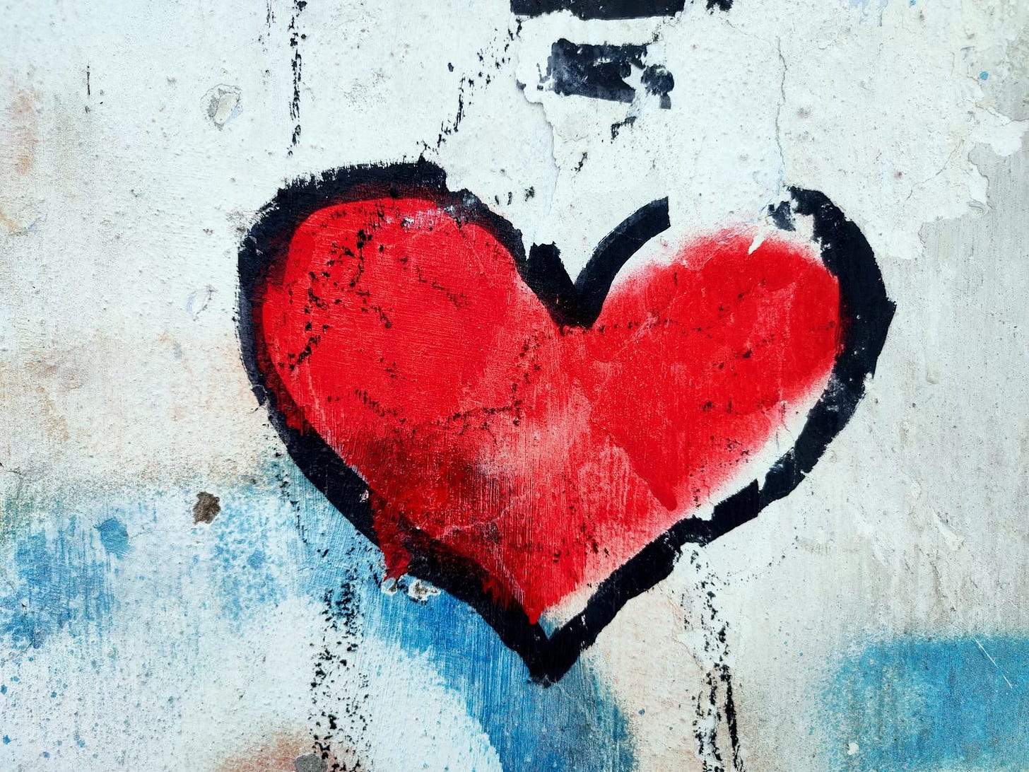 a red heart with a thick black border on a blue and white wall