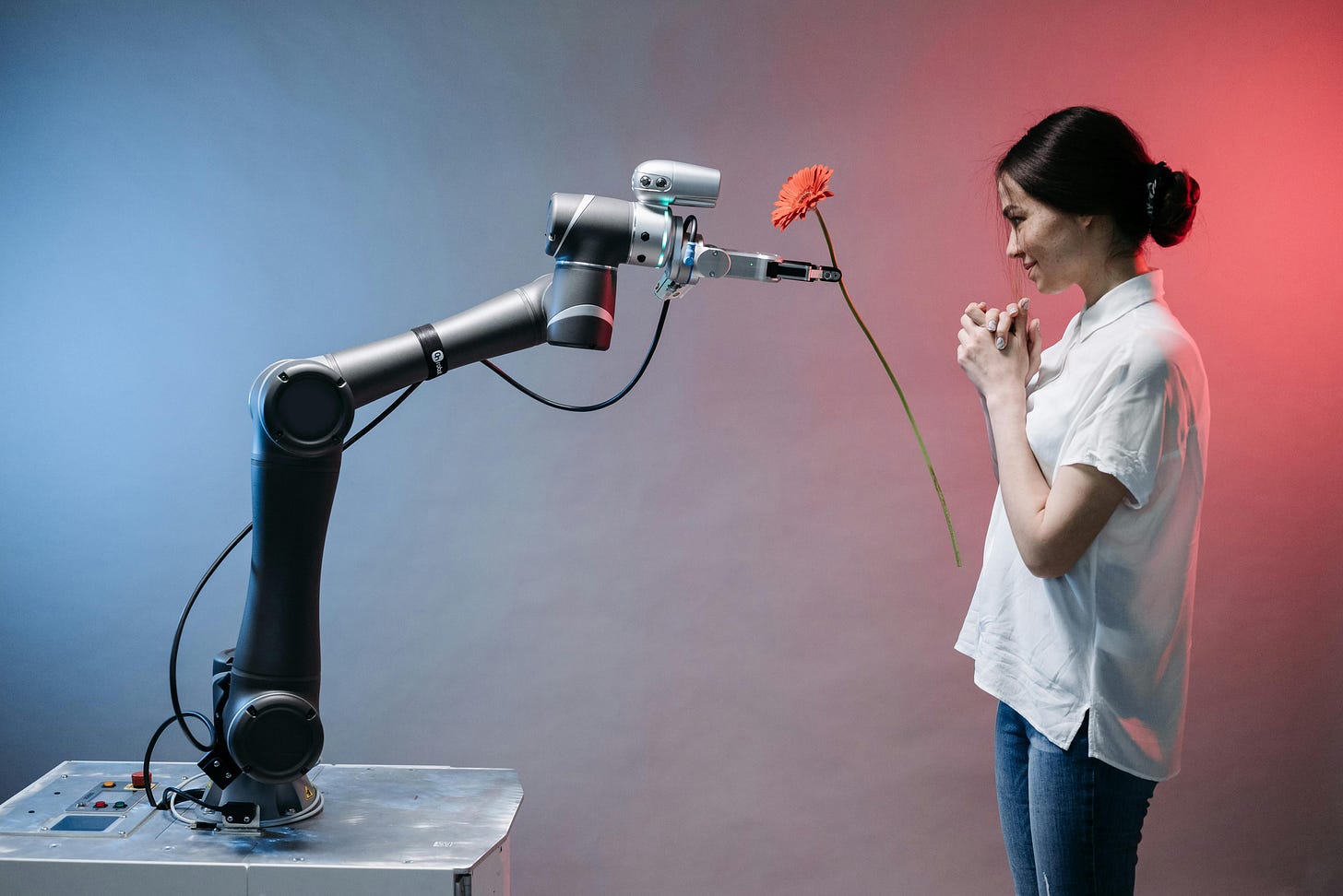 A robotic arm hands a woman a flower A robotic arm hands a woman a flower