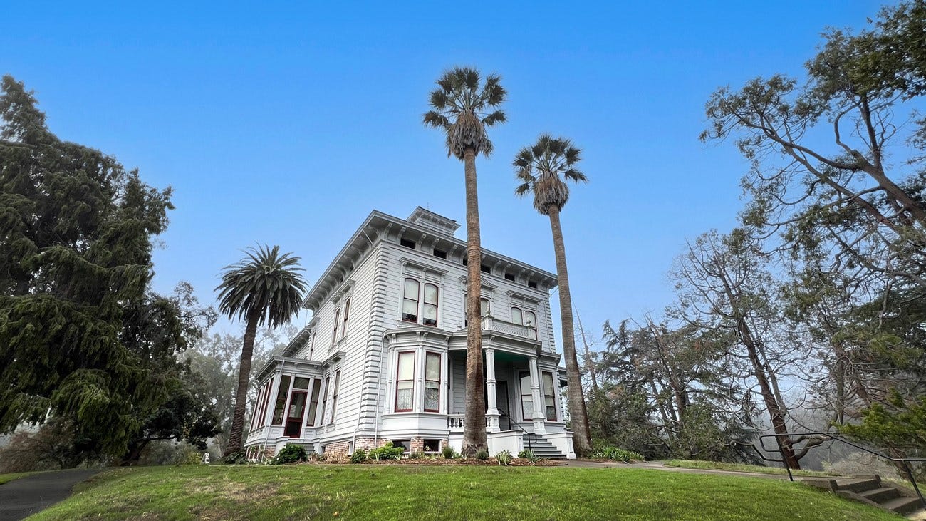 Photograph of the Strentzel/Muir home. Trees on all sides of a victorian two story home. Photograph of the Strentzel/Muir home. Trees on all sides of a victorian two story home.