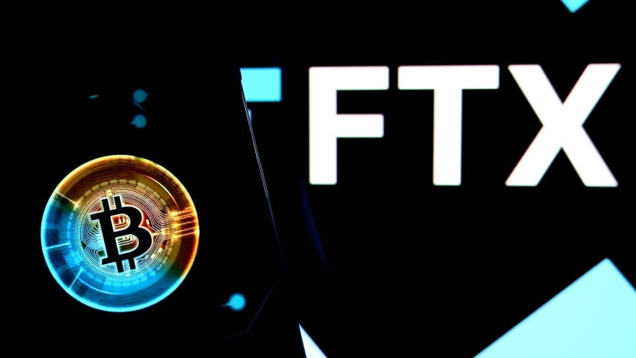 INDIA - 2022/11/21: In this photo illustration, a bitcoin logo seen displayed on a smartphone with a FTX logo on the background. (Photo Illustration by Avishek Das/SOPA Images/LightRocket via Getty Images)