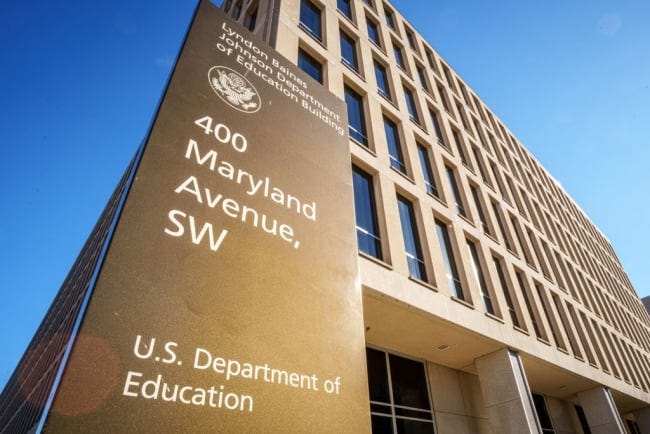 A sign with the Education Department’s address stands next to the building.