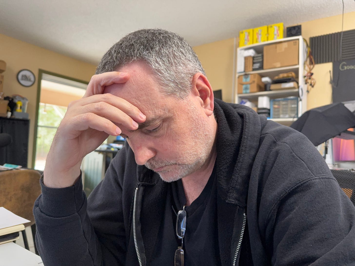 A picture of Donovan Adkisson staring down at something with his head propped up by one hand. 