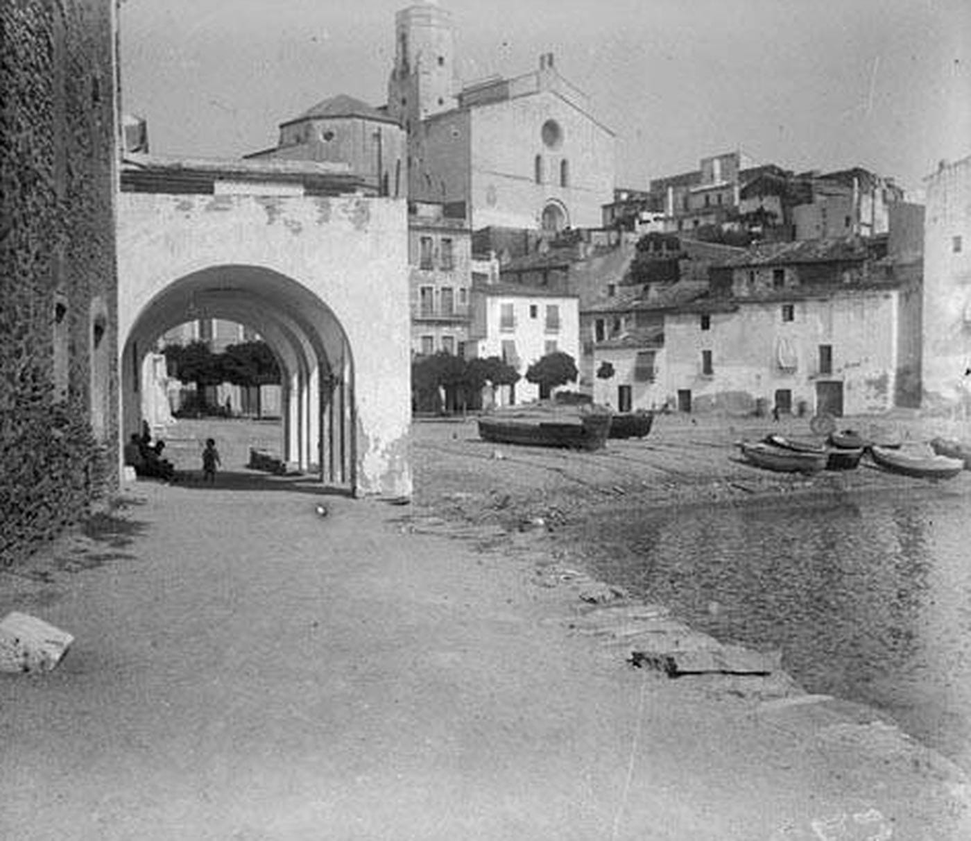 The village of Cadaqués seen from the shore, with boats pulled up on the sand and the church above the houses. The village of Cadaqués seen from the shore, with boats pulled up on the sand and the church above the houses.