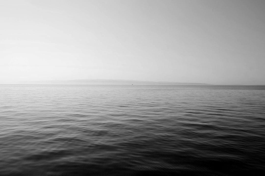 body of water under blue and white sky at daytime body of water under blue and white sky at daytime