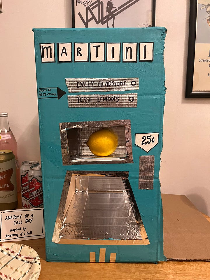 Cardboard box painted to look like a Martini vending machine & an image of the vending machines from Asteroid City for stockings, cocktails, coffee & ammunition.