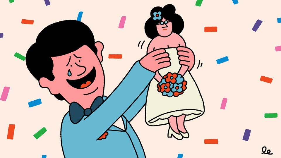 A man adoringly holding up a doll-like version of his wife