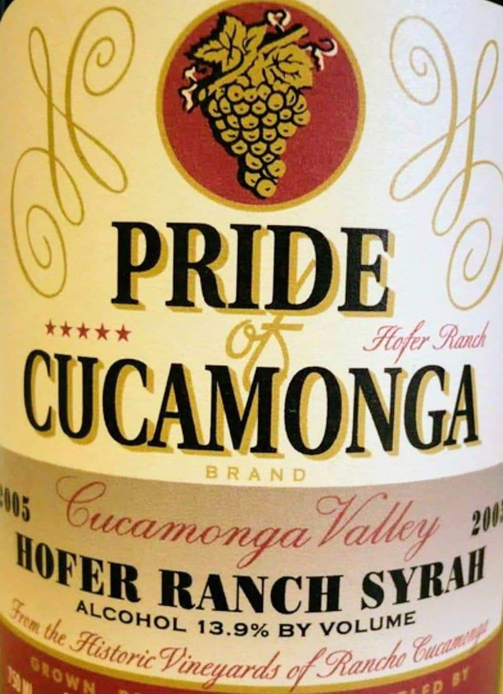Wine label for Pride of Cucamonga Hofer Ranch Syrah from the Cucamonga Valley, showing a golden grape cluster crest on cream background.