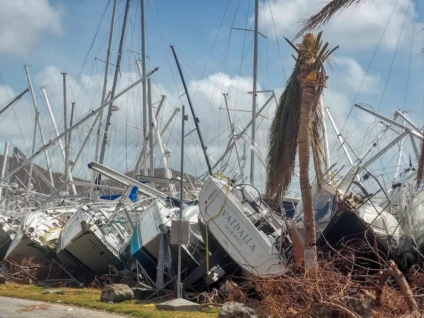 A row of sailing boats which have all been blown on to their sides