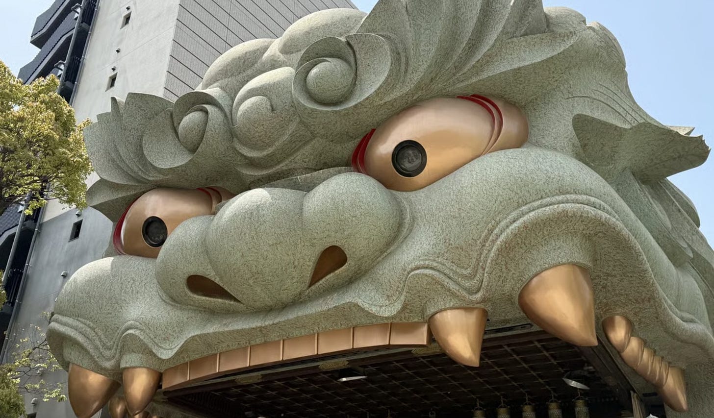 Close-up of the massive, stone lion-head stage at Namba Yasaka Shrine in Osaka.