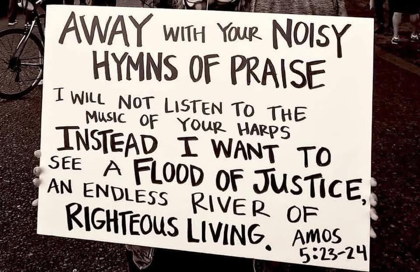 May be an image of 2 people and text that says 'AWAY YOUR NOISY HYMNS OF PRAISE I WILL NOT LISTEN To THE MUSIC OF INSTEAD YOUR HARPS I WANT SEE A to AN ENDLESS FLOOD OF RIVER JUSTICE, RIGHTEOUS LIVING. OF AMOS 5:23-24'