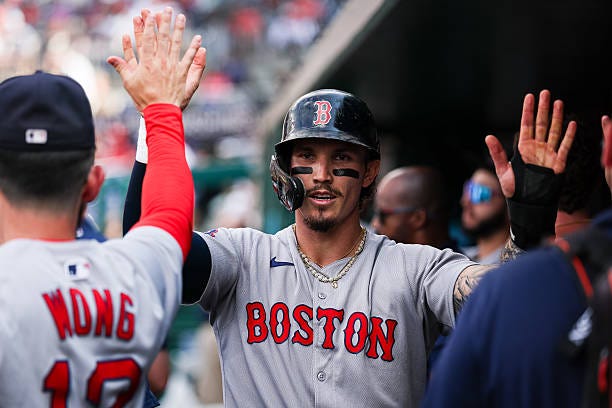Jarren Duran of the Boston Red Sox celebrates with teammates in the dugout after scoring a run against the Washington Nationals during the third...