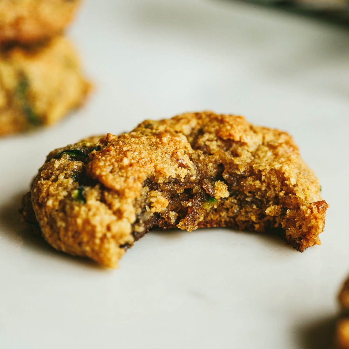 Brown butter zucchini cookie with a bite taken out of it.