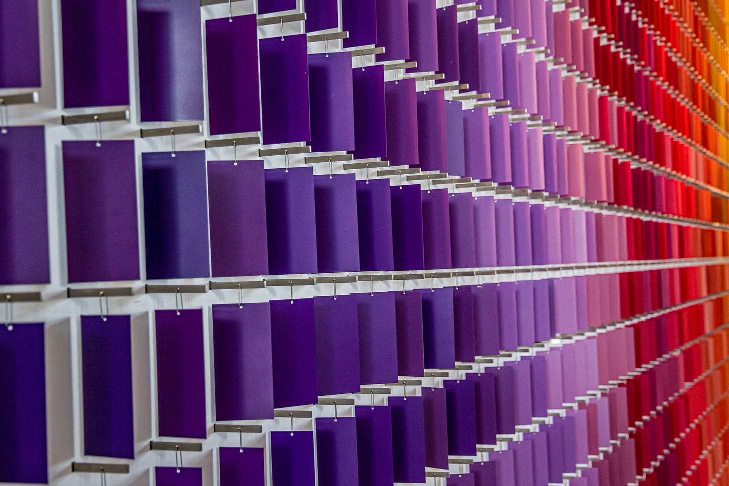 Strings of paper paint chips moving through from purple to orange