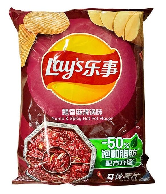 A packet of Lay's "Numb & Spicy Hot Pot Flavor" potato chips in a purple packet, with both Chinese and English lettering.