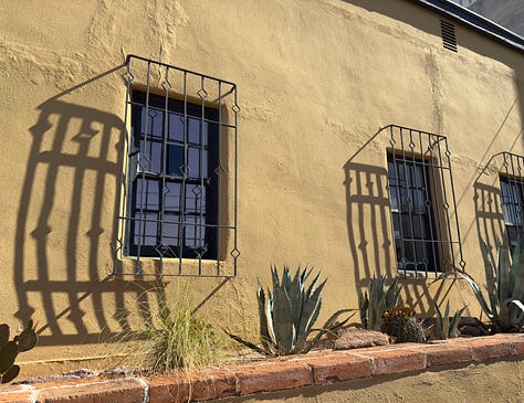 The photos display nine homes in the Sonoran architectural style traditional to the Southwest of the United States. The homes feature flat roofs, front walls that begin at the sidewalk's edge, colorful stucco exterior walls, and large windows.